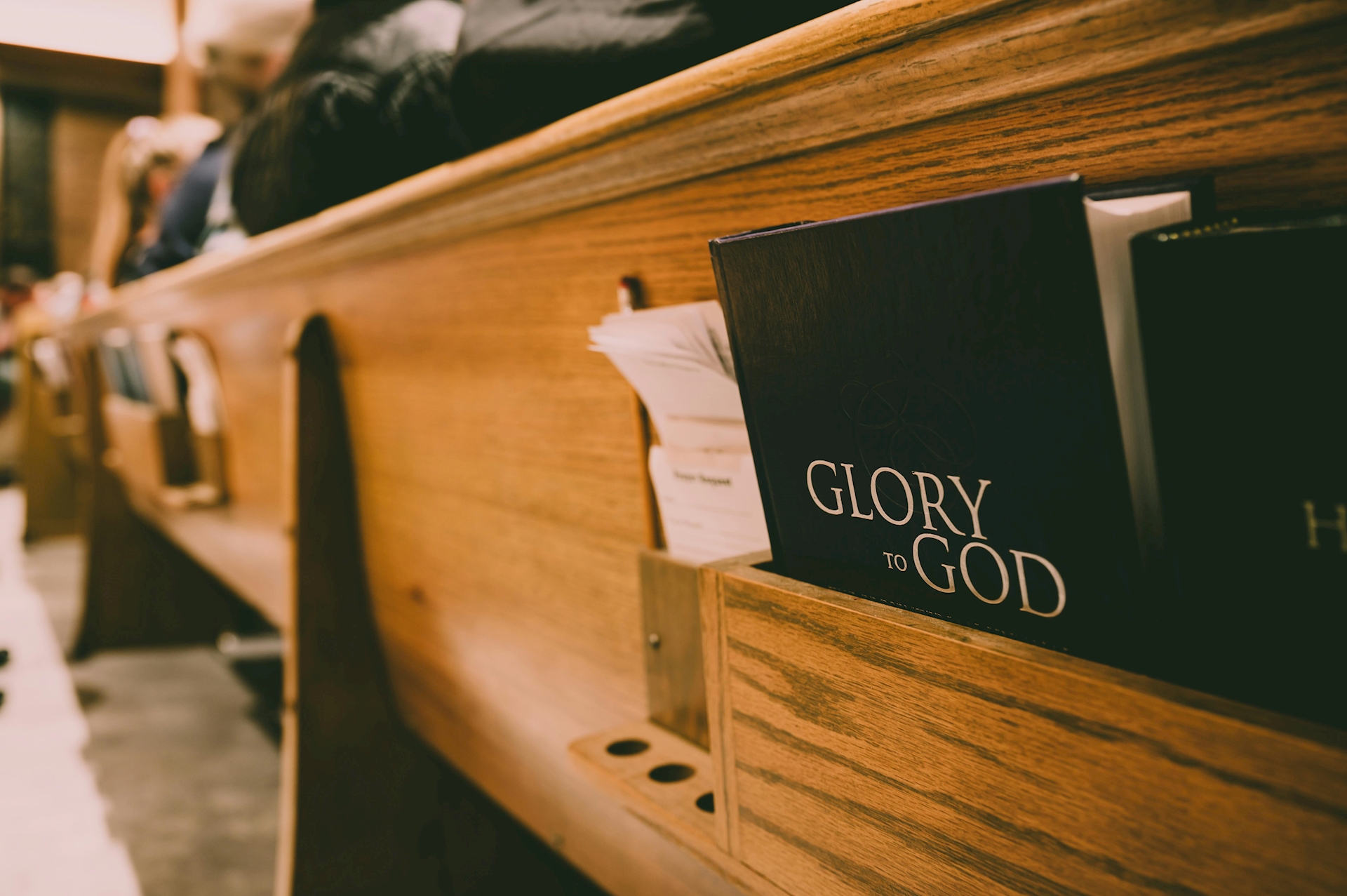 Bible that says "Glory to God" in church pew